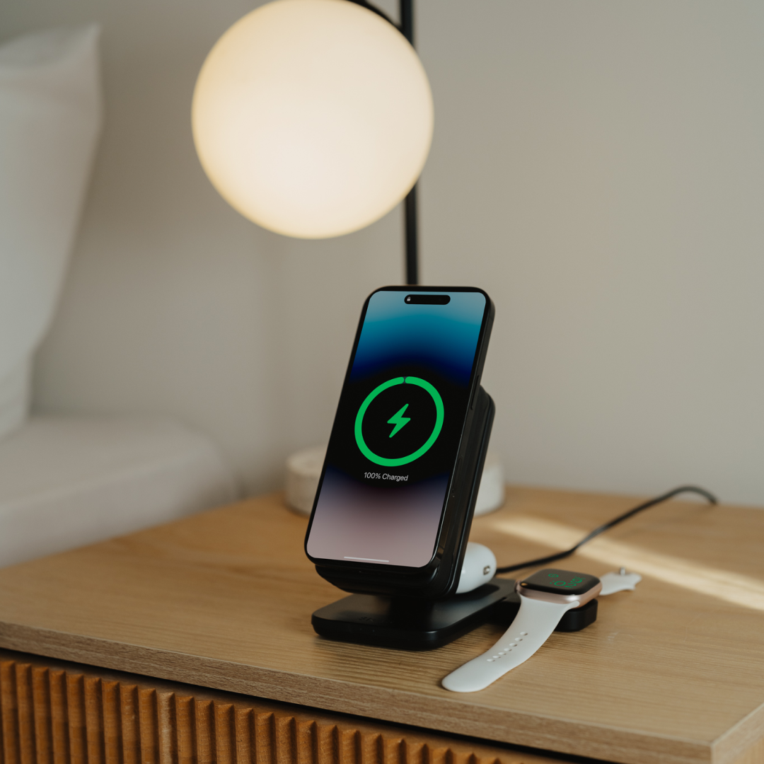 Wireless charging stand on a nightstand with smartphone and smartwatch