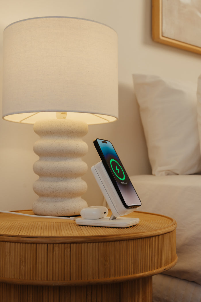 The PowerDock 2 on a bedside table at night, phone charging on top