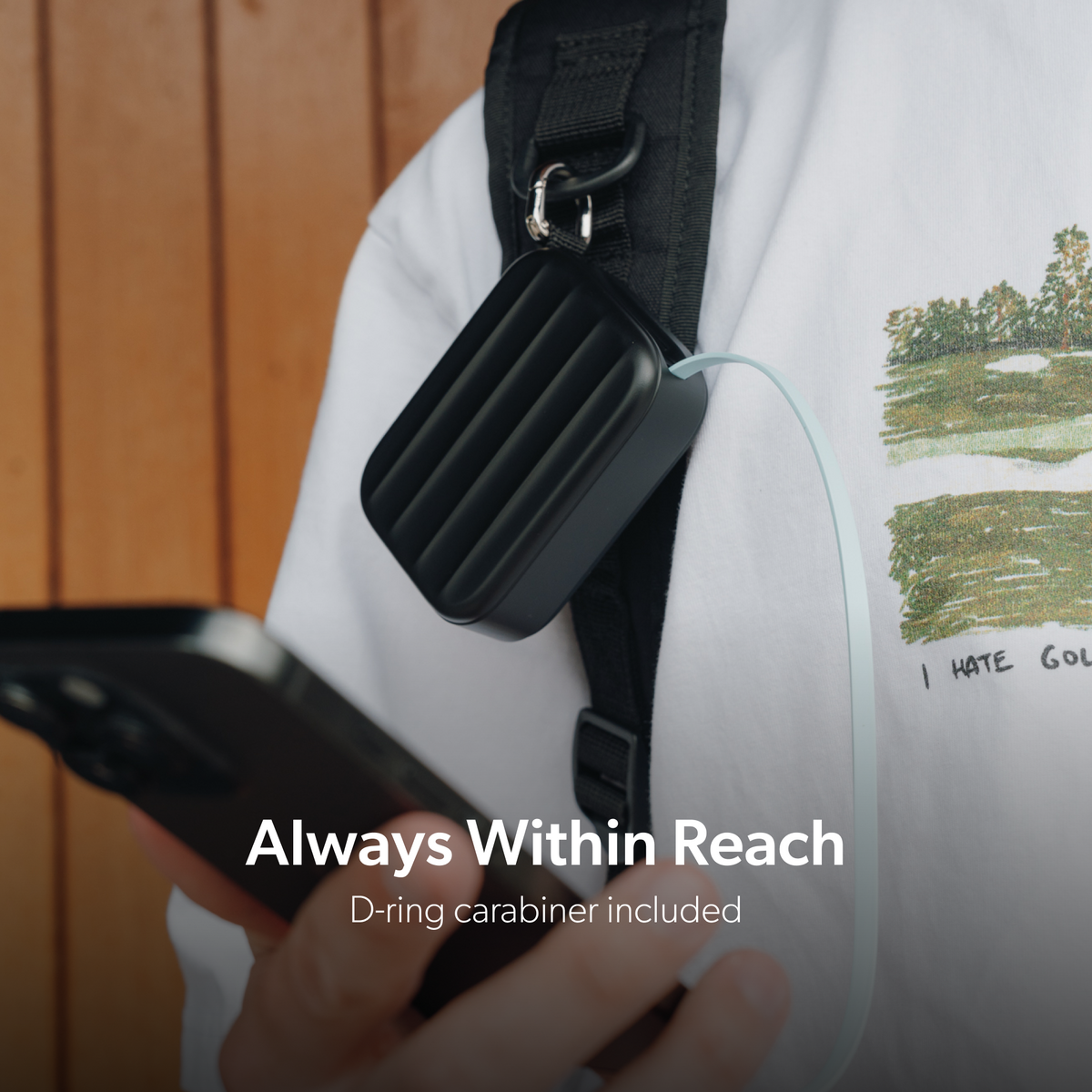 Black PowerPack Mini 2 clipped to a backpack strap with the included D-ring carabiner.