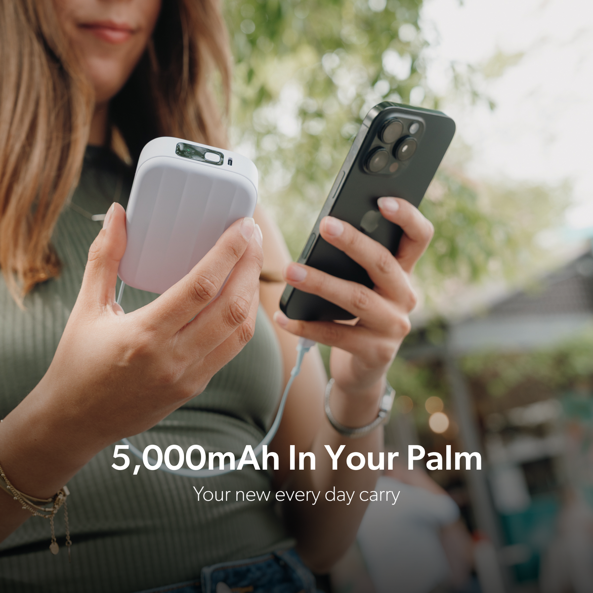 Palm-sized lavender PowerPack Mini 2 connected to a phone, with 5,000mAh capacity.