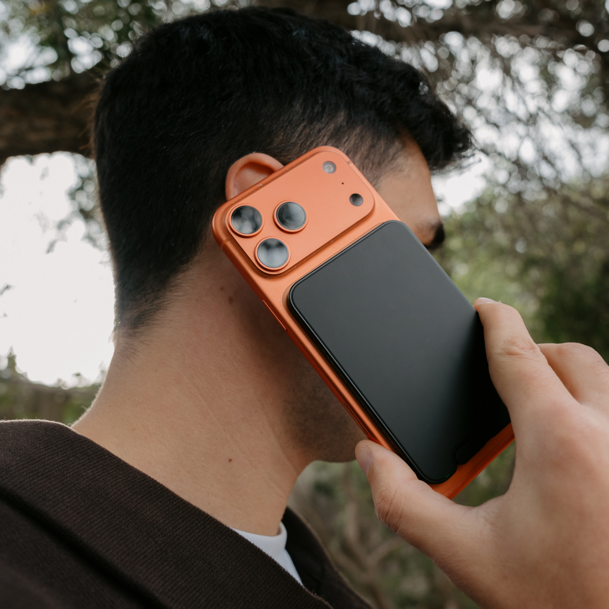 Man making a phone call with Titan Black PowerPack Slim 3 attached to his smartphone