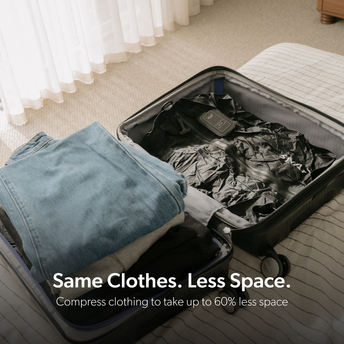Compressed TRVLR Vacuum Bag packed beside jeans in a suitcase